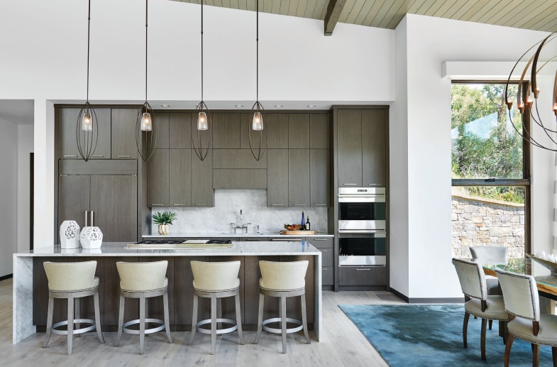 Designer Paul Cathers chose earth tones for this kitchen, where the family gathers for everything from meals to doing homework and playing music. PHOTO BY AUBREY DALLAS